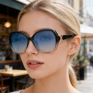 Detailaufnahme der quadratischen Oversized-Sonnenbrille mit blauem Verlauf und Goldakzenten