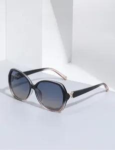 Detailsicht der Verlaufsgläser und Goldmetall-Akzente auf der eckigen Oversized-Sonnenbrille