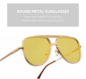 Détail de lunettes pilote carrées avec monture en métal doré mat et verres jaunes