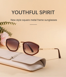 Detail of square metal frame sunglasses on leather case with warm floral backdrop
