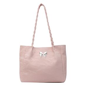 Detail of pink tote bag with textured surface and silver butterfly metal ornament