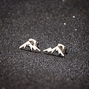 Macro shot of silver mountain silhouette studs with polished finish and metal backings