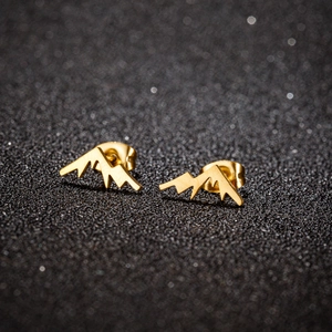 Minimalist gold snow mountain peak stud earrings for women on a dark elegant background
