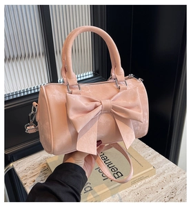 Detail of pink Boston handbag with large bow decoration and adjustable shoulder strap
