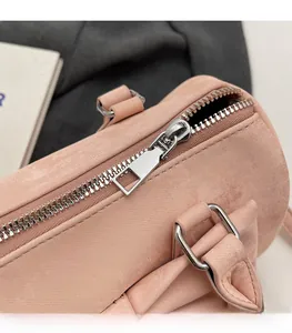 Close-up of silver metal zipper and hardware on a pink leather Boston bag
