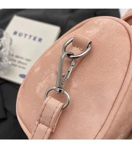 Close-up of polished silver hardware buckle and shimmering pink faux leather texture