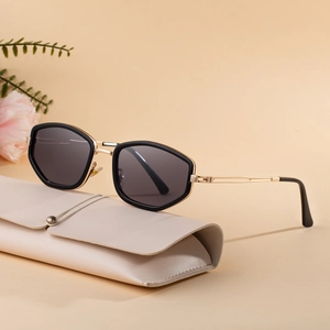 Chic black geometric sunglasses with gold temples and cream leather case on floral background