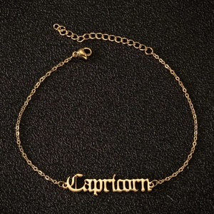 Detail der goldenen Capricorn Fußkette mit gotischer Schrift und verstellbarem Verschluss
