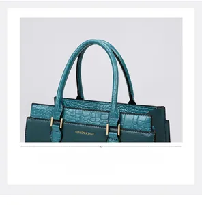 Close-up of deep teal tote bag featuring lychee and crocodile textures with gold hardware