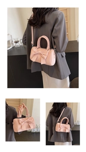 Detailed view of pink bow leather boston bag with adjustable strap and handles