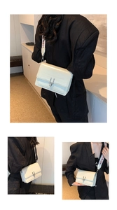 Detail of cream square crossbody bag featuring silver buckle and ethnic pattern strap