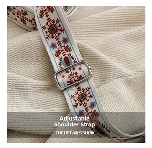 Detail view of ethnic embroidered shoulder strap with red snowflake and silver buckle