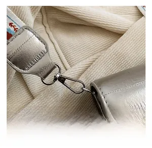 Close-up of premium silver metal hook with textured woven strap on vintage crossbody bag