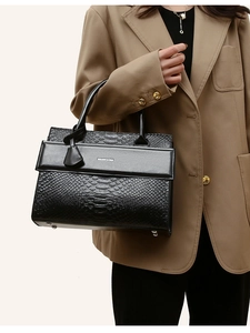 Macro view of black crocodile pattern leather texture with Balado & Bag brand stamp