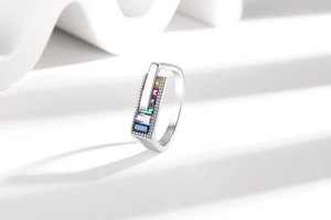 Detailed close-up of rainbow rectangular zircon ring with geometric silver frame