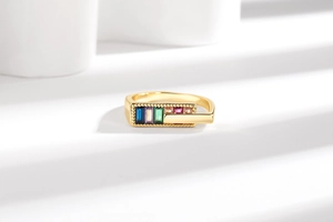 Macro view of gold ring featuring five colorful rectangular zircons with bead edging