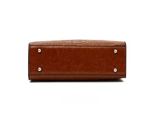 Detailed bottom view of brown crocodile embossed handbag with four silver metal feet