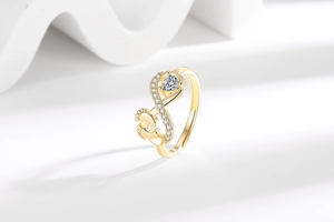 Macro view of gold heart zircon ring featuring cute baby footprint details on the band