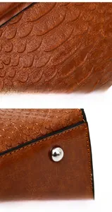 Detail showing brown crocodile embossed leather texture and silver bottom protective studs