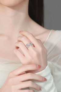 Detail shot of a silver infinity ring with sparkling crystals on a model's hand