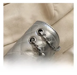 Macro shot of silver quilted faux leather with metallic chain strap and grommet detail
