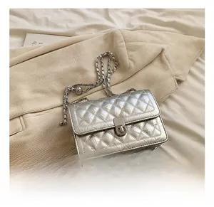 Detail showing the shiny silver quilted texture and metal chain strap of the crossbody bag