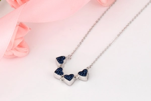 Détail des cristaux bleu foncé sur un collier cœur trèfle à quatre feuilles