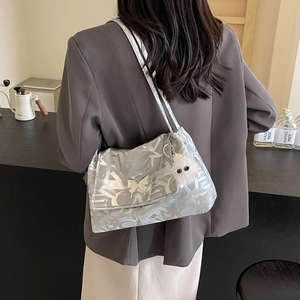 Silver tote bag with graffiti texture, butterfly charm and plush monster pendant detail