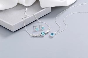 Close-up of silver jewelry set with blue heart crystals on geometric display stands