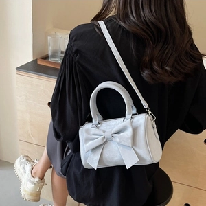 Chic light blue bow cylinder bag with dual handles and adjustable crossbody strap