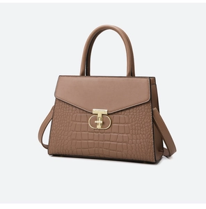 Detail of crocodile embossed leather texture and gold T-shaped clasp on brown tote bag