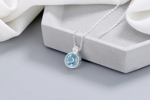 Macro view of blue crystal pendant with polished silver setting and detailed metalwork