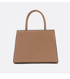 Detail of brown faux leather handbag showing smooth texture and cylindrical handles