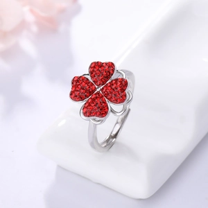 Détail macro d'une bague réglable en argent avec trèfle en cristal rouge serti