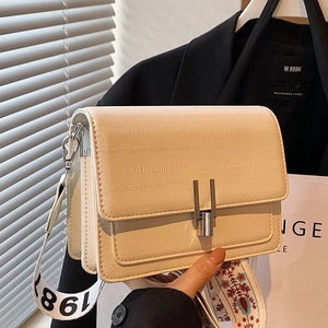 Chic beige crocodile-pattern crossbody bag with stylish wide straps and silver lock