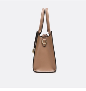 Side view of khaki textured leather handbag showing golden D-rings and top handles