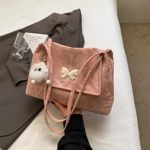 Close-up of pink nylon tote bag with letter print pattern and butterfly decoration
