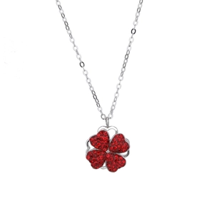 Vue détaillée du pendentif trèfle rotatif avec cristaux de cœur rouges sur chaîne