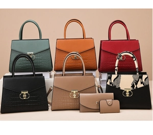 Detail shot of handbag set with crocodile pattern, matching wallets, and gold T-bar buckle