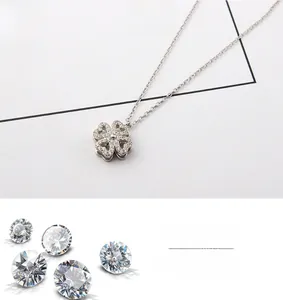 Detailed close-up of a rotating silver clover pendant necklace with sparkling zircons