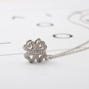 Macro shot of silver four-leaf clover necklace with sparkling micro-pave heart petals