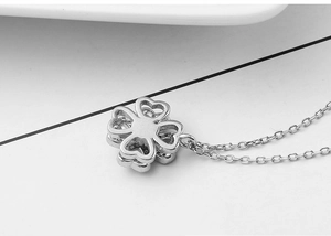 Macro view of silver four-leaf clover necklace pendant with micro-pave stone setting