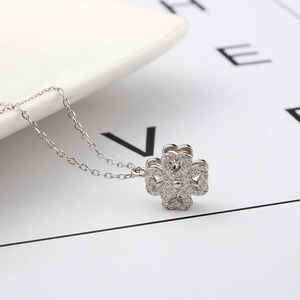 Detail of clover pendant with heart-shaped petals and sparkling crystals on fine silver chain