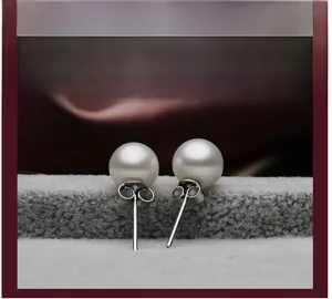 Detail of round white pearl earrings with silver posts and butterfly back closures