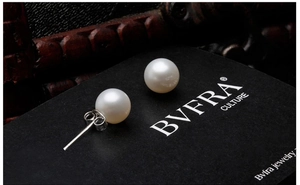 Macro shot of 925 silver round pearl earrings displayed on a luxury black jewelry card