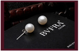 Macro shot of 8mm round white pearls with 925 silver needles on vintage black background
