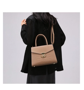 Brown crocodile pattern handbag featuring a metal T-shaped buckle and adjustable strap