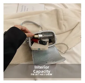 Detail view of mini silver box bag interior showing capacity for phone and lipstick