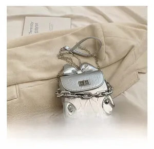 Detail of silver bow-knot box bag with thick chain strap and ruched leather texture