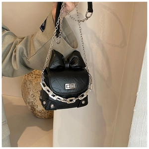 Detail of black mini box bag featuring pleated PU leather and oversized bow decoration